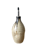 Decorative ceramic bottle with metallic cap on a white background