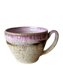 Two ceramic cappuccino cups with beige, bronze, and pink speckled glaze, stacked on top of each other.