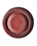 A ceramic dinnerware set featuring a round platter and a matching shallow bowl, both in a speckled terracotta red glaze with dark charcoal-brown distressed accents around the rims, shown from a top-down view on a white background.