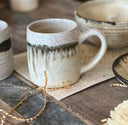 Ceramic mug surrounded by other pottery