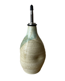 Ceramic olive oil dispenser with a textured surface on a white background