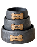 Set of three metal pet bowls with bone-shaped nameplates on a white background