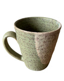 Speckled green ceramic mug on a white background