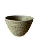 Speckled green ceramic bowl on a white background