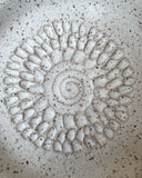 Decorative stone with a sunflower pattern on a speckled surface