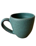 Teal ceramic mug with speckled texture on a white background