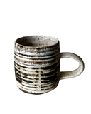 Ceramic mug with black ribbed pattern on a white background