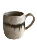 Ceramic coffee cup in white and beige with a bronze stripe on a white background. 
