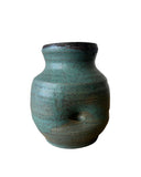 A teal and bronze vase on a white background. The vase has a thumprint. 