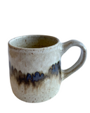 Ceramic mug with brown and blue speckles on a white background
