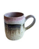 Ceramic mug with a gradient color pattern on a white background