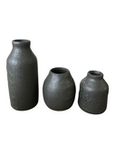 Three textured black vases of different sizes on a white background