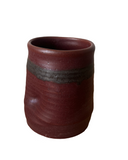 A collection of five handmade ceramic tumblers with various colored interiors.