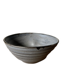 Stacked brown stoneware pasta bowls with bronze speckles and a bronze accent along the lip.
