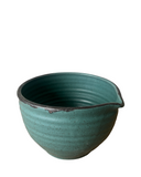 Teal ceramic bowl with a ribbed texture on a white background