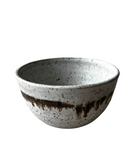 Speckled ceramic bowl with brown accent on a white background