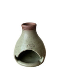 A green palo santo burner on a white background. 