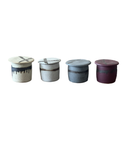Four ceramic butter pots with lids in different colors on a white background