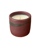 Ceramic candle holder with a lit candle on a white background