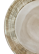 Close-up of a ceramic plate with textured edge on a white background