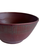 burgundy red ceramic bowl with grid pattern on a white background