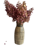 Bouquet of dried flowers in a textured vase on a white background