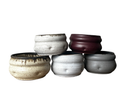 Five ceramic pots of various sizes and colors on a white background