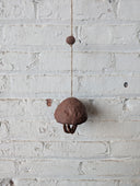Decorative wall piece with brown ceramic elements on a white brick wall