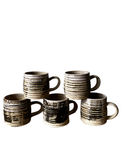 Set of five ceramic mugs with textured design on a white background