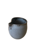 Ceramic pitcher with a speckled finish on a white background