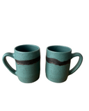 Two teal ceramic mugs with brown stripes on a white background