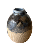 Ceramic vase with textured surface on a white background