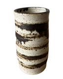 Ceramic cup with black and white speckled pattern on a white background