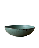 Teal ceramic bowl on a white background