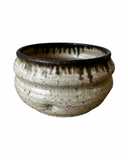 A collection of handcrafted brown stoneware flower pots with a matte glaze and bronze accents, displayed against a white background.