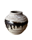 Ceramic vase with black and white glaze on a white background