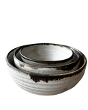 Set of three ceramic bowls with brown glaze on a white background