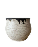 A beige and bronze ceramic utensil crock or vase on a white background. 