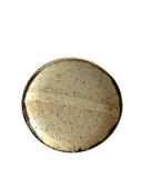 a beige plate on a white background