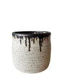 A beige and bronze ceramic utensil crock or vase on a white background. 