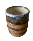 Ceramic pot with striped design on a white background