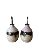 Two ceramic bottles with black speckles on a white background