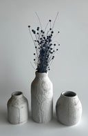 Three textured ceramic vases on a plain background
