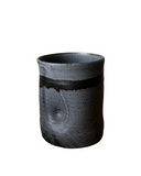 A collection of five handmade ceramic tumblers with various colored interiors.