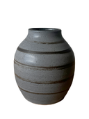 A collection of four ceramic vases, with the Luna Striped Vase in the foreground. The vases are crafted from brown stoneware clay with striped patterns in various shades of bronze.