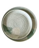 A ceramic side plate with a satin avocado green glaze, featuring brown stoneware clay with speckles.