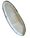 Oval-shaped ceramic plate with a textured surface on a white background