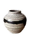 Ceramic vase with a black band on a white background