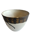 Ceramic bowl with black and gold design on a white background