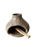 A green palo santo burner on a white background. 